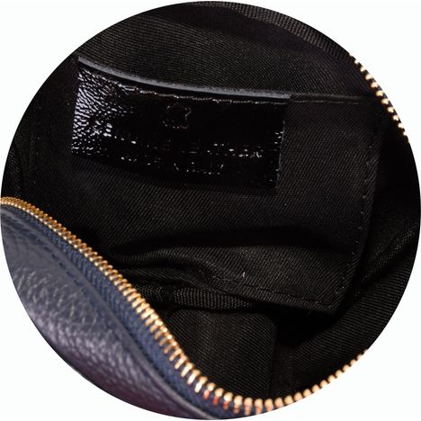 Close up of patch pocket inside the main compartment of a ladies navy blue leather shoulder bag