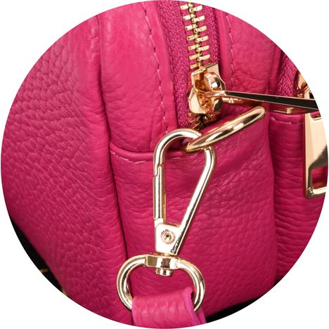 close up of a chunky gold metal strap clip on a womens pink small crossbody handbag