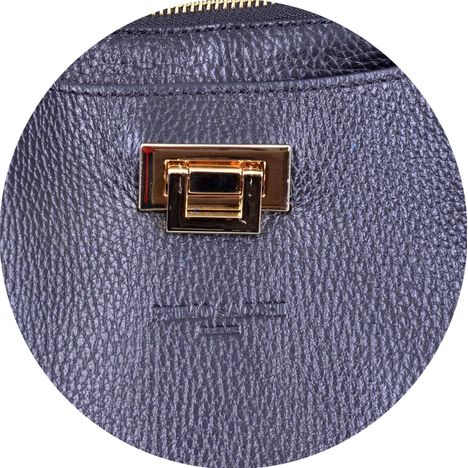 close up of a gold metal flip clasp on a ladies large black italian leather handbag