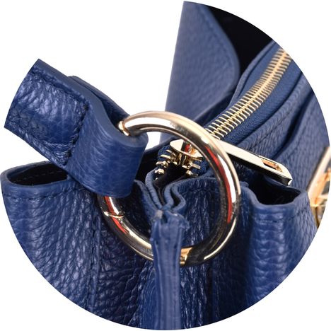 close up of the gold metal ring holding the handle on a dark blue italian leather handbag