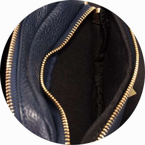 close up of the interior of the front compartment of a womens small navy blue leather bag