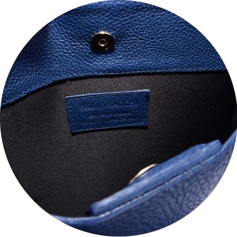 close up of a magnetic popper on a ladies blue leather tote grab and shoulder bag
