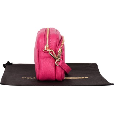 side view of a closed womens small pink leather shoulder crossbody bag with gold metalware 
