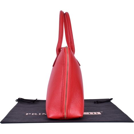 side view of a large bright red italian leather bowling style bag with base to base gold metal zip